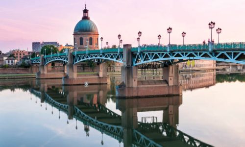 Saint-Pierre Bridge reflecting in Garonne river and Dome de la Grave at sunset in Toulouse, France